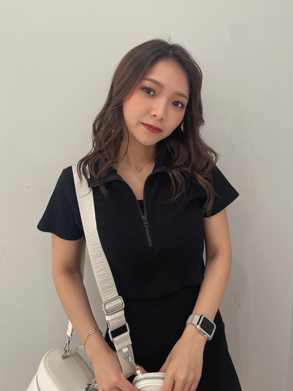 ブラック系のワンピース、ブラック系のハンドバッグ、ホワイト系のブーツを着用したレディースの春コーディネートの4枚目の写真