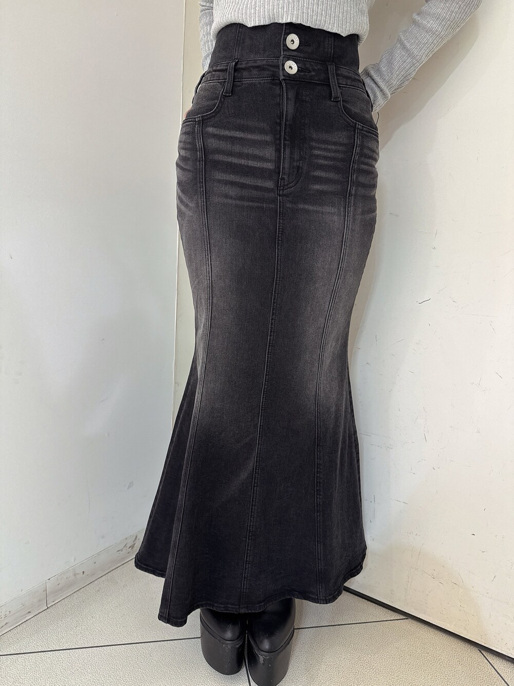 ブラック系のデニムスカート、ブラック系のTシャツ/カットソー、ホワイト系のパンプスを着用したレディースの秋コーディネートの8枚目の写真