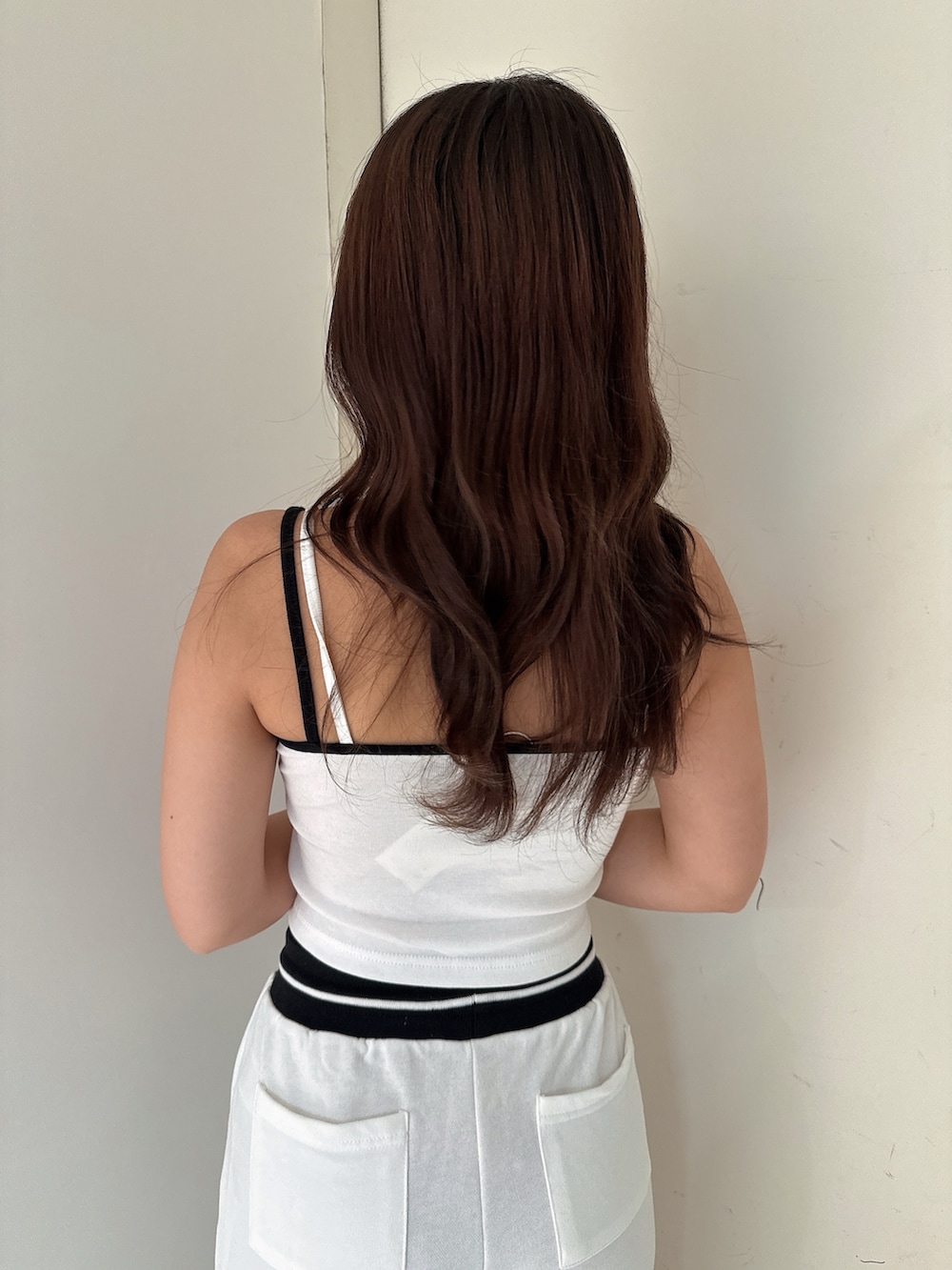 ブラック系のサンダル、ホワイト系のスウェットパンツ、ホワイト系のキャミソールを着用したレディースの夏コーディネートの6枚目の写真