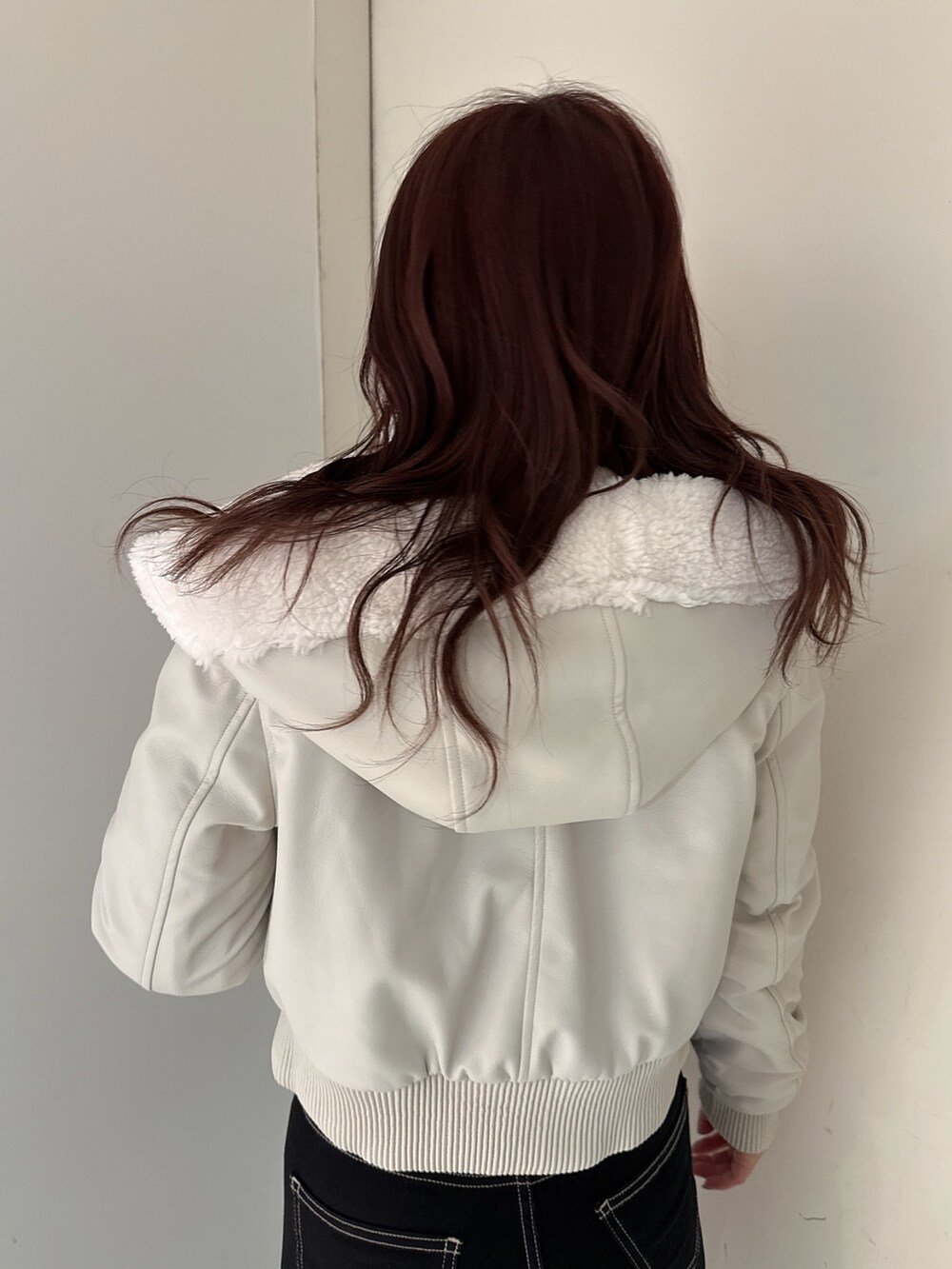 ブラック系のデニムパンツ、ブラック系のブーツ、ホワイト系のその他アウターを着用したレディースの冬コーディネートの6枚目の写真