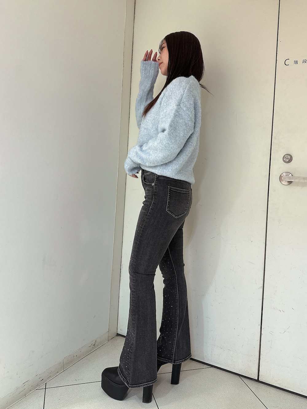 ブラック系のブーツ、ブルー系のニット/セーター、ブラック系のデニムパンツを着用したレディースの冬コーディネートの2枚目の写真