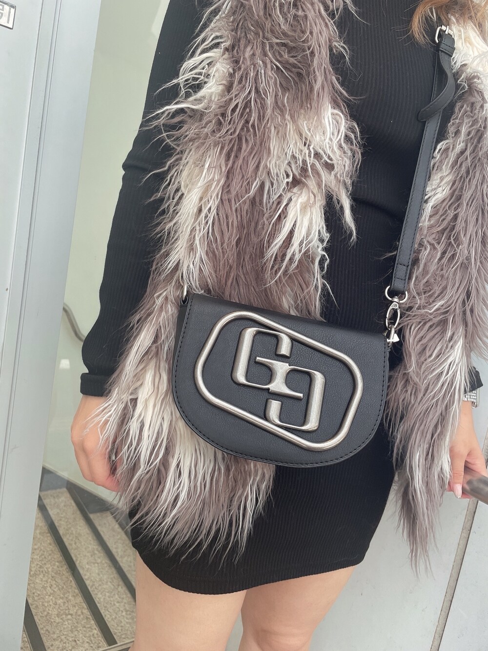 ブラック系のワンピース、その他のベスト、ブラック系のハンドバッグを着用したレディースの秋コーディネートの7枚目の写真