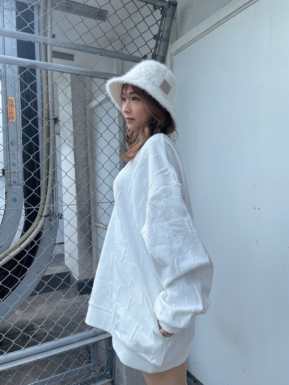 ホワイト系のスウェット、ブラック系のスカート、ベージュ系のブーツを着用したレディースの冬コーディネートの5枚目の写真