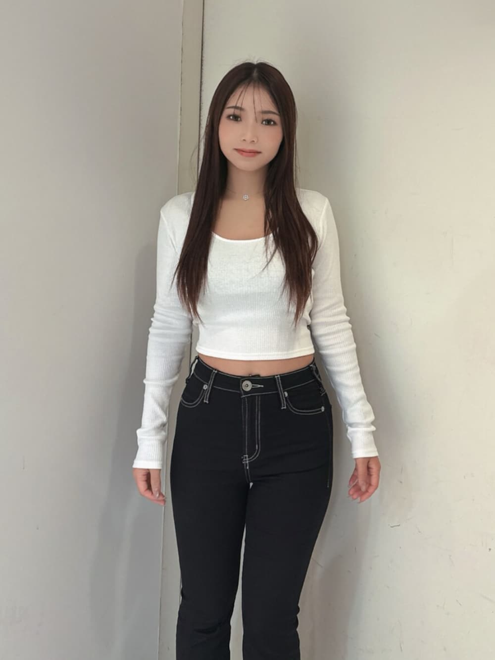ブラック系のデニムパンツ、ブラック系のブーツ、ホワイト系のTシャツ/カットソーを着用したレディースの夏コーディネートの4枚目の写真