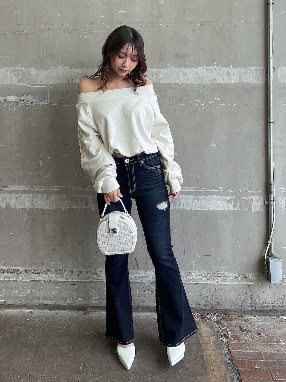ホワイト系のスウェット、ホワイト系のハンドバッグ、ホワイト系のパンプスを着用したレディースの春コーディネートの2枚目の写真