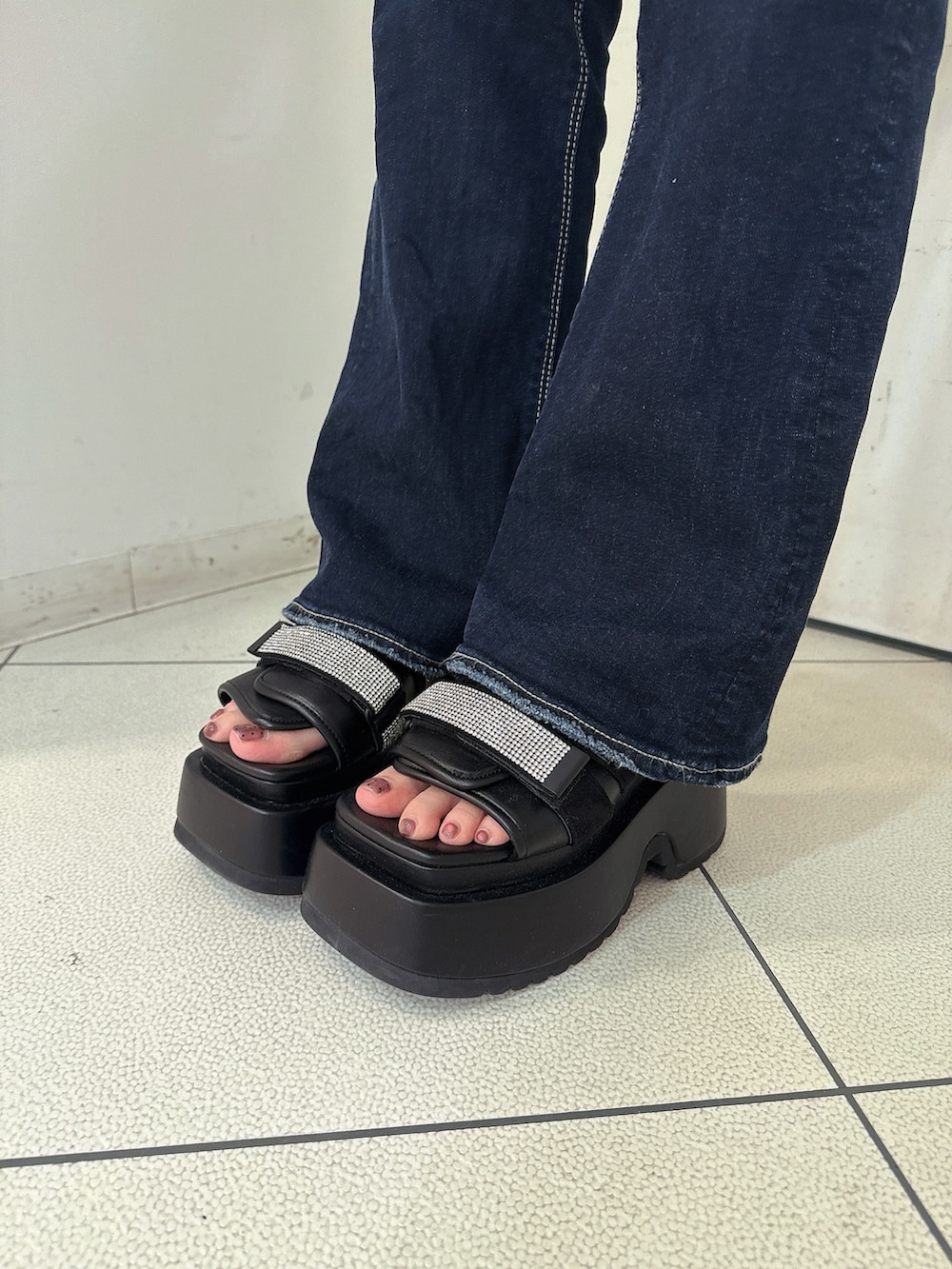 ブルー系のデニムパンツ、ブルー系のニット/セーター、ブラック系のサンダルを着用したレディースの春コーディネートの9枚目の写真