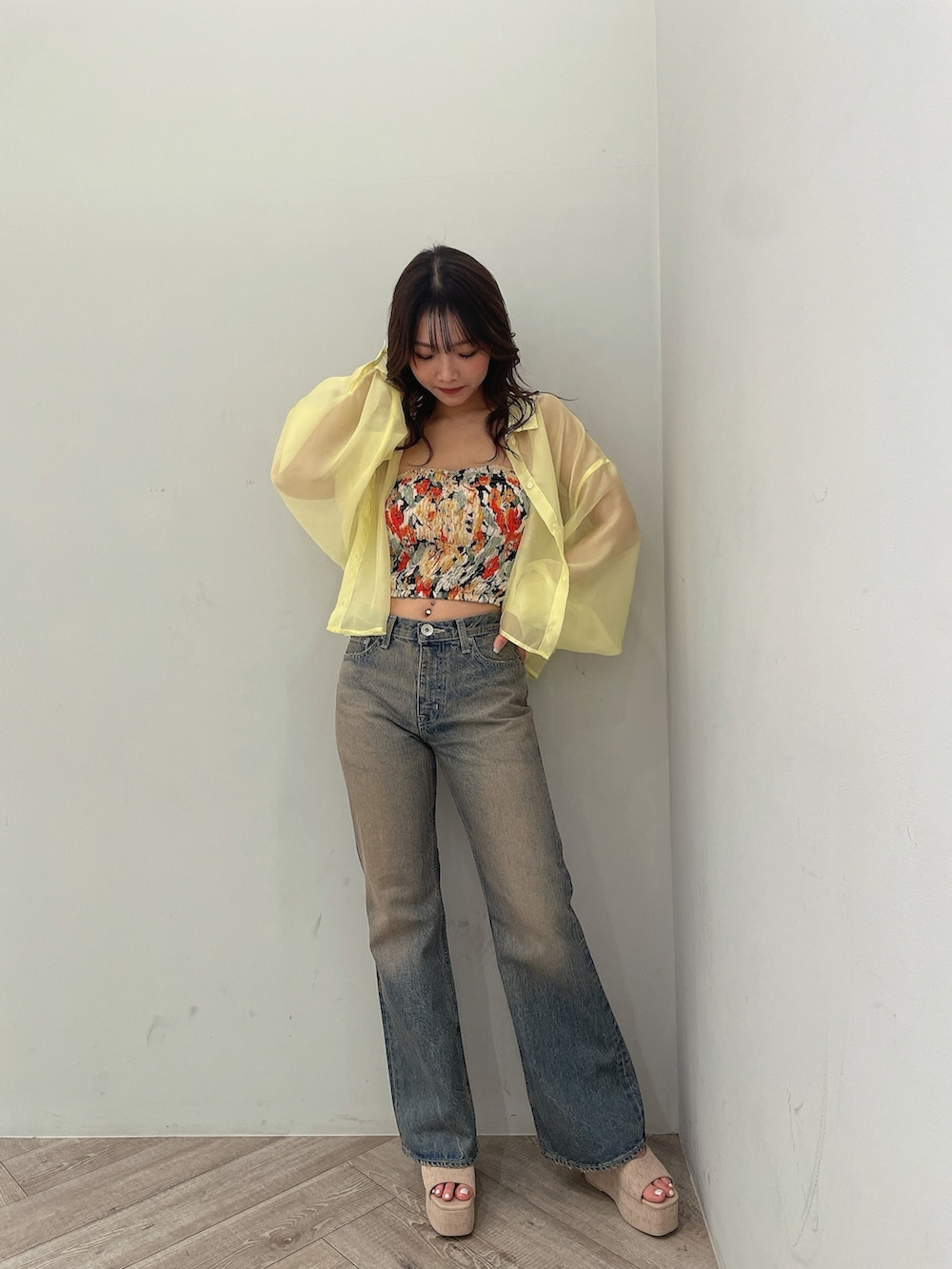 イエロー系のシャツ/ブラウス、ブラック系のチューブトップ、ブルー系のデニムパンツを着用したレディースの春コーディネートの2枚目の写真