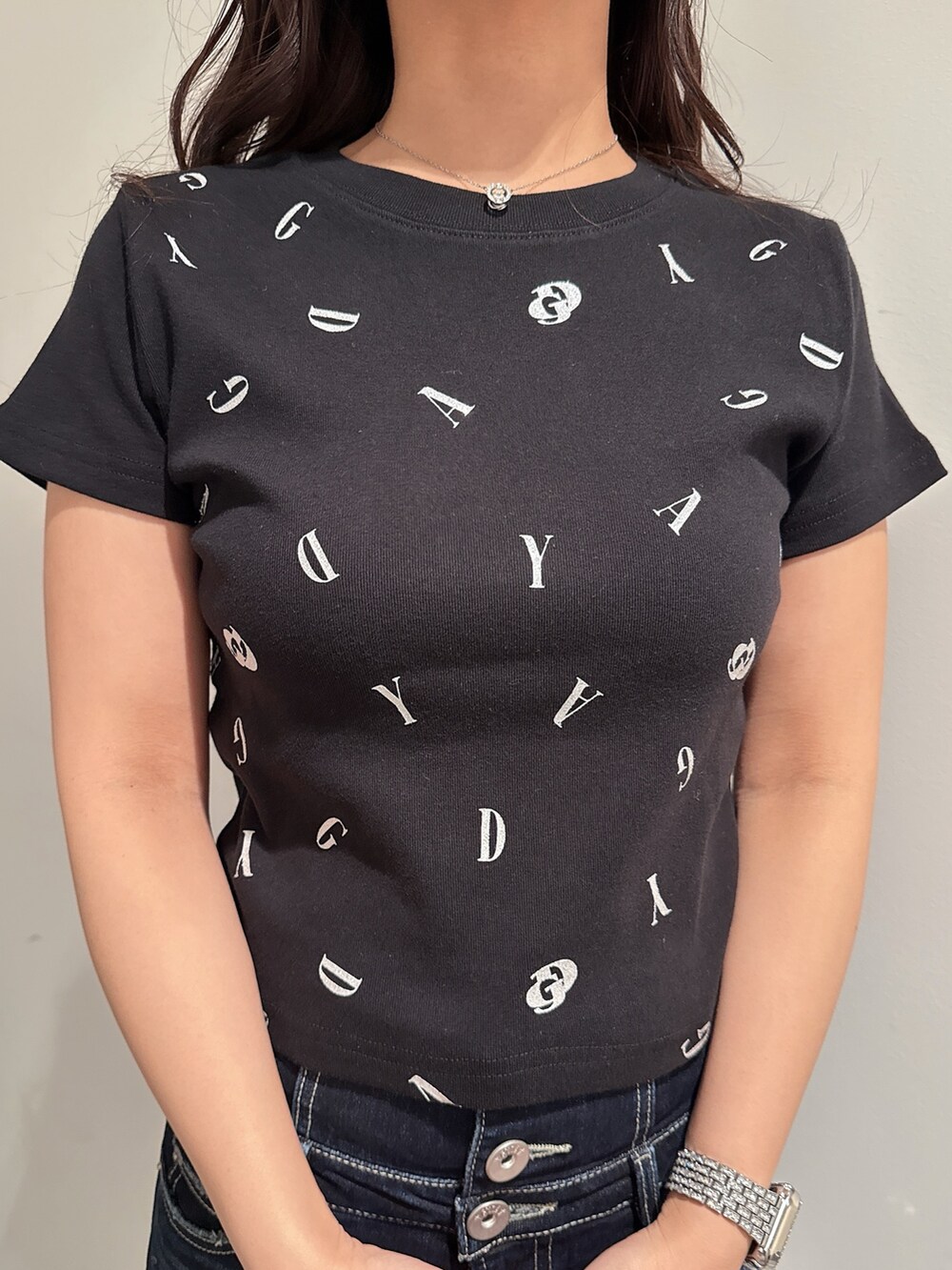 ブラック系のTシャツ/カットソー、ブルー系のデニムパンツ、ブラック系のサンダルを着用したレディースの春コーディネートの7枚目の写真