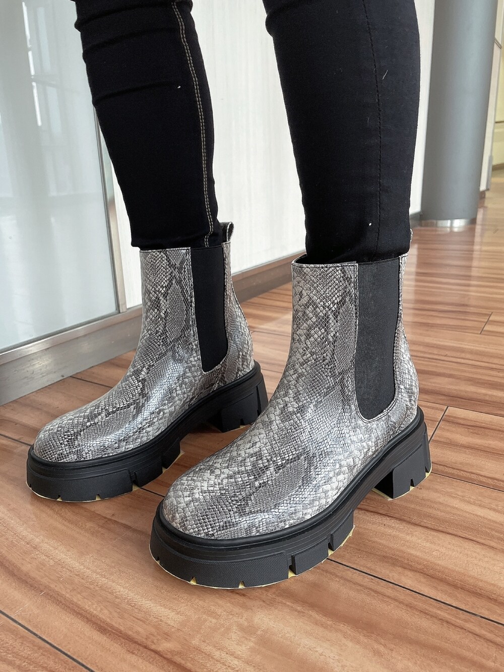 ホワイト系のスウェット、ブラック系のデニムパンツ、その他のブーツを着用したレディースの冬コーディネートの6枚目の写真