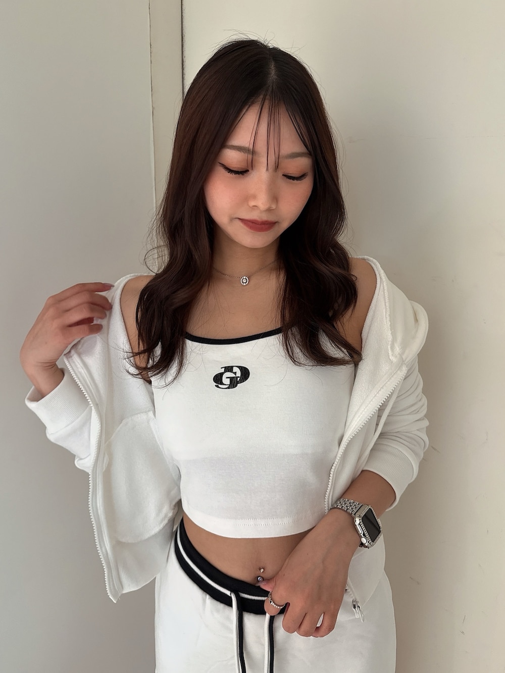 ホワイト系のキャミソール、ブラック系のサンダル、ホワイト系のパーカーを着用したレディースの夏コーディネートの4枚目の写真