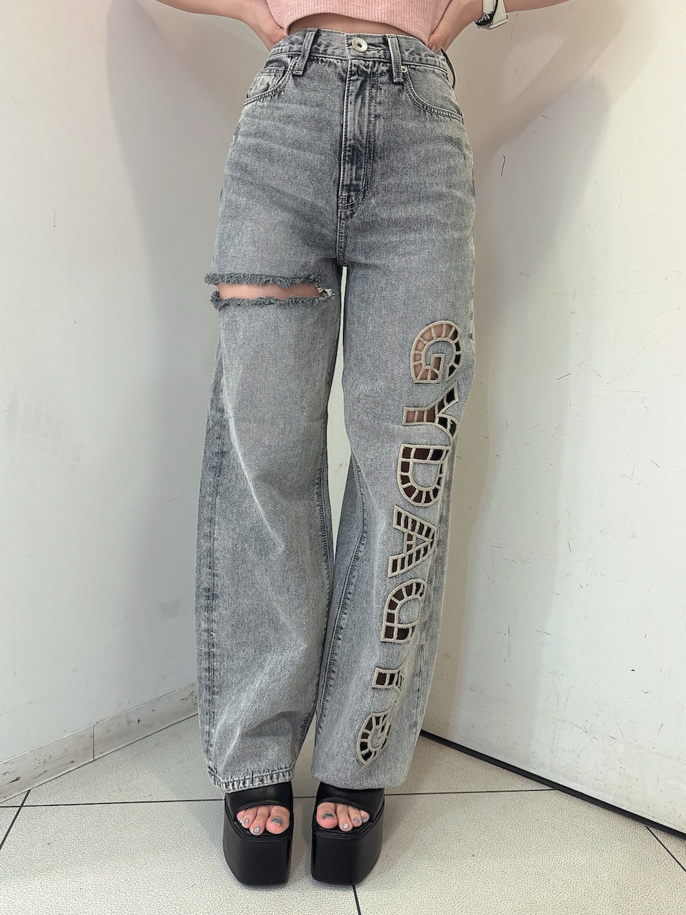 ブルー系のデニムパンツ、ブラック系のサンダル、パープル系のキャミソールを着用したレディースの春コーディネートの8枚目の写真