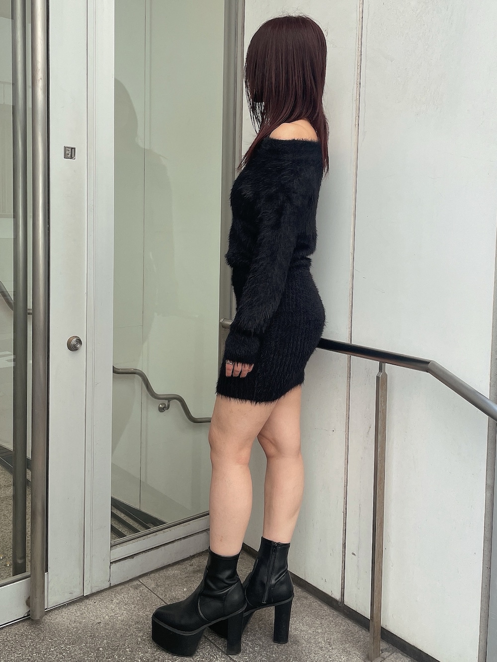 ブラック系のブーツ、ブラック系のワンピース、グレー系のライダースジャケットを着用したレディースの秋コーディネートの6枚目の写真