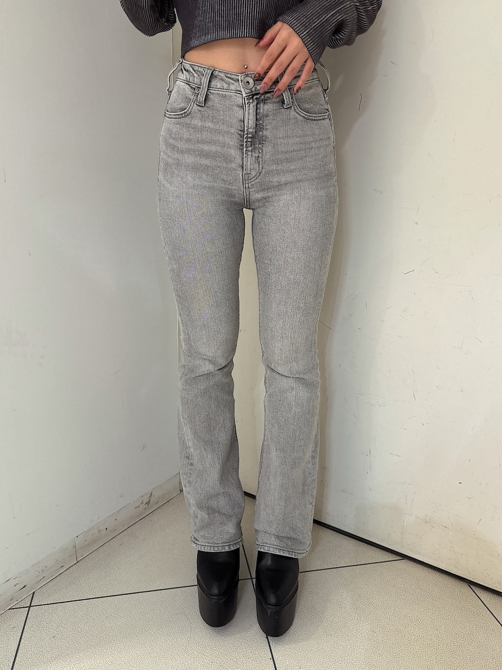 グレー系のデニムパンツ、ブラック系のブーツ、ブラック系のライダースジャケットを着用したレディースの夏コーディネートの8枚目の写真