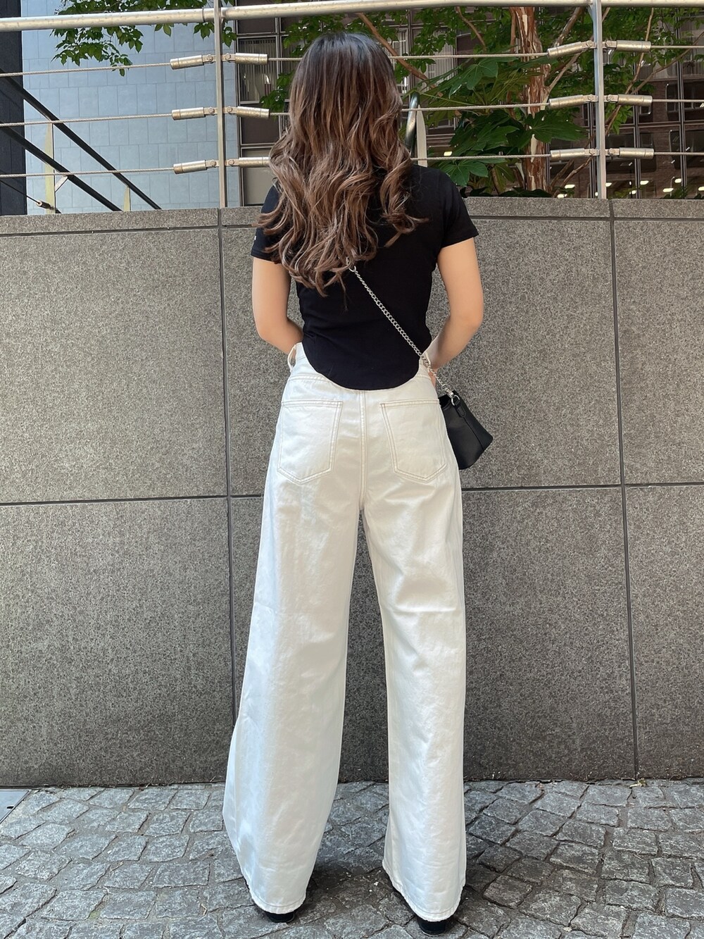 ブラック系のTシャツ/カットソー、ブラック系のショルダーバッグ、ブラック系のサンダルを着用したレディースの夏コーディネートの3枚目の写真