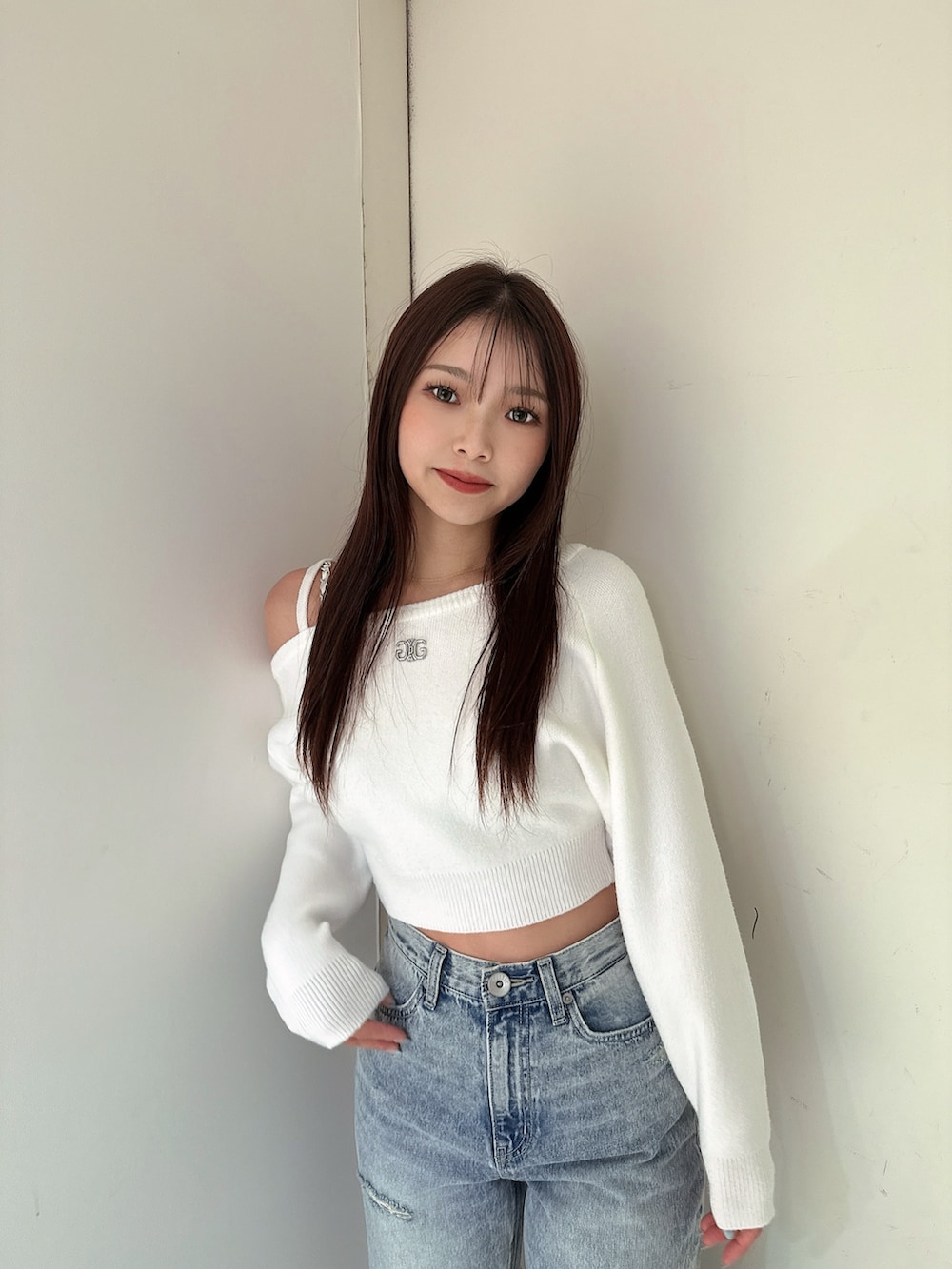 ホワイト系のニット/セーター、ブルー系のデニムパンツ、ホワイト系のパンプスを着用したレディースの冬コーディネートの4枚目の写真