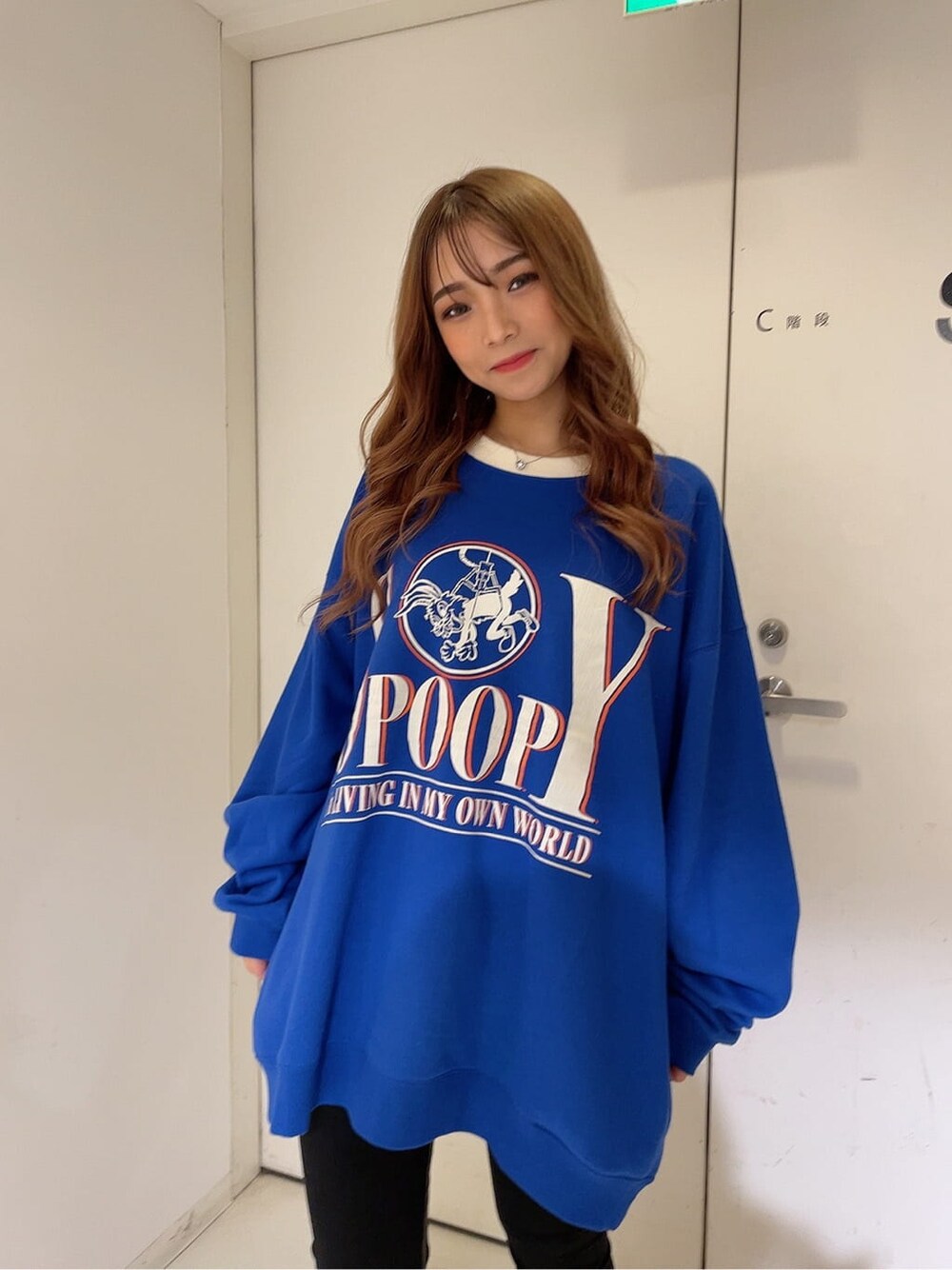 ブラック系のパンプス、ブラック系のデニムパンツ、ブルー系のスウェットを着用したレディースの秋コーディネートの2枚目の写真