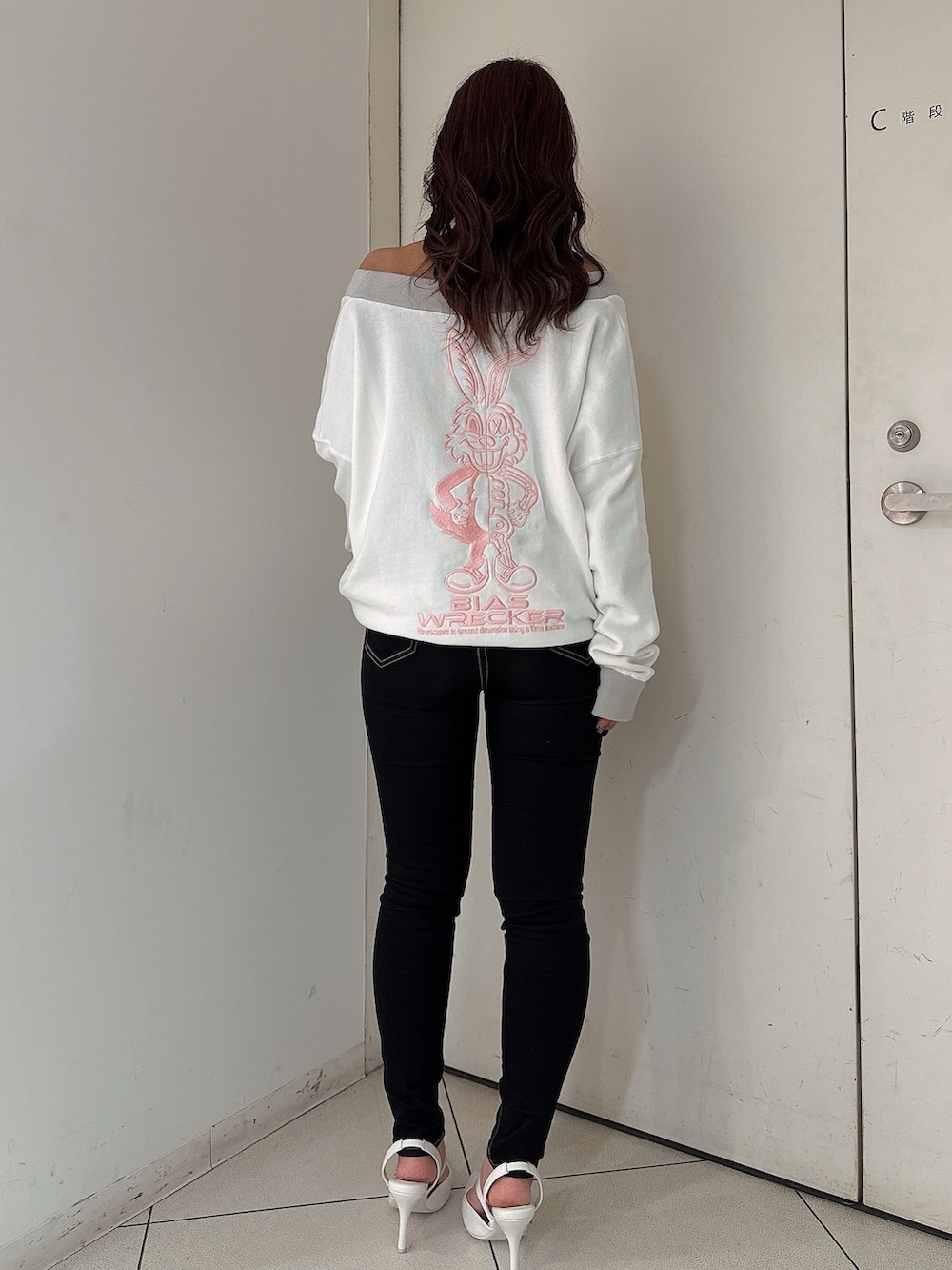 ブラック系のデニムパンツ、ホワイト系のスウェット、ホワイト系のパンプスを着用したレディースの冬コーディネートの3枚目の写真