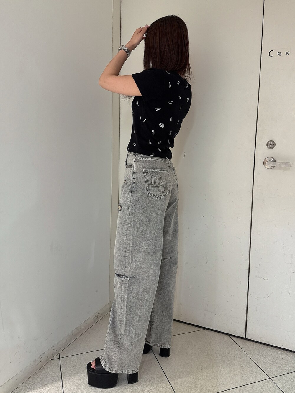 ブラック系のTシャツ/カットソー、ブルー系のデニムパンツ、ブラック系のサンダルを着用したレディースの夏コーディネートの2枚目の写真