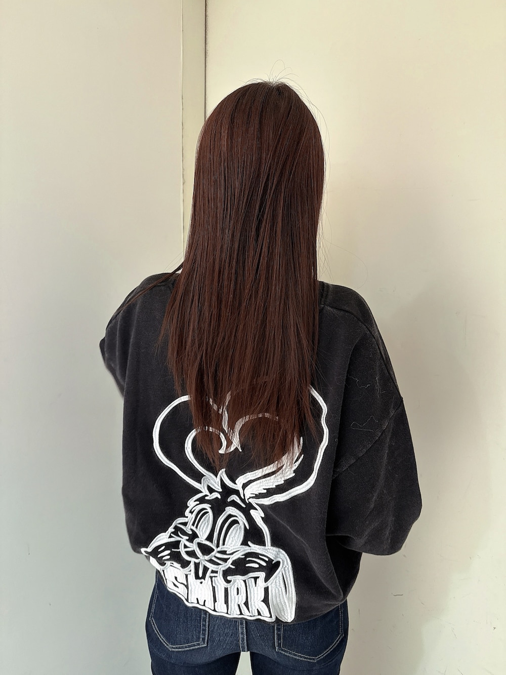 ブルー系のデニムパンツ、ブラック系のスウェット、ブラック系のブーツを着用したレディースの冬コーディネートの6枚目の写真