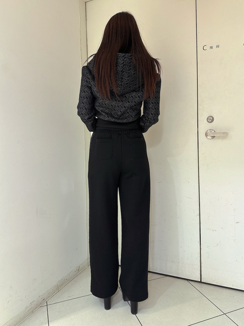 ブラック系のスウェットパンツ、ブラック系のパーカー、ブラック系のブーツを着用したレディースの冬コーディネートの3枚目の写真