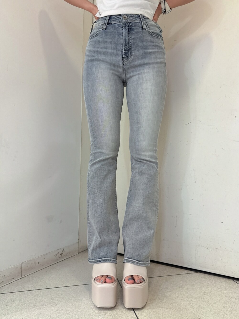 ブルー系のデニムパンツ、ブラック系のサンダル、ホワイト系のブルゾンを着用したレディースの春コーディネートの8枚目の写真