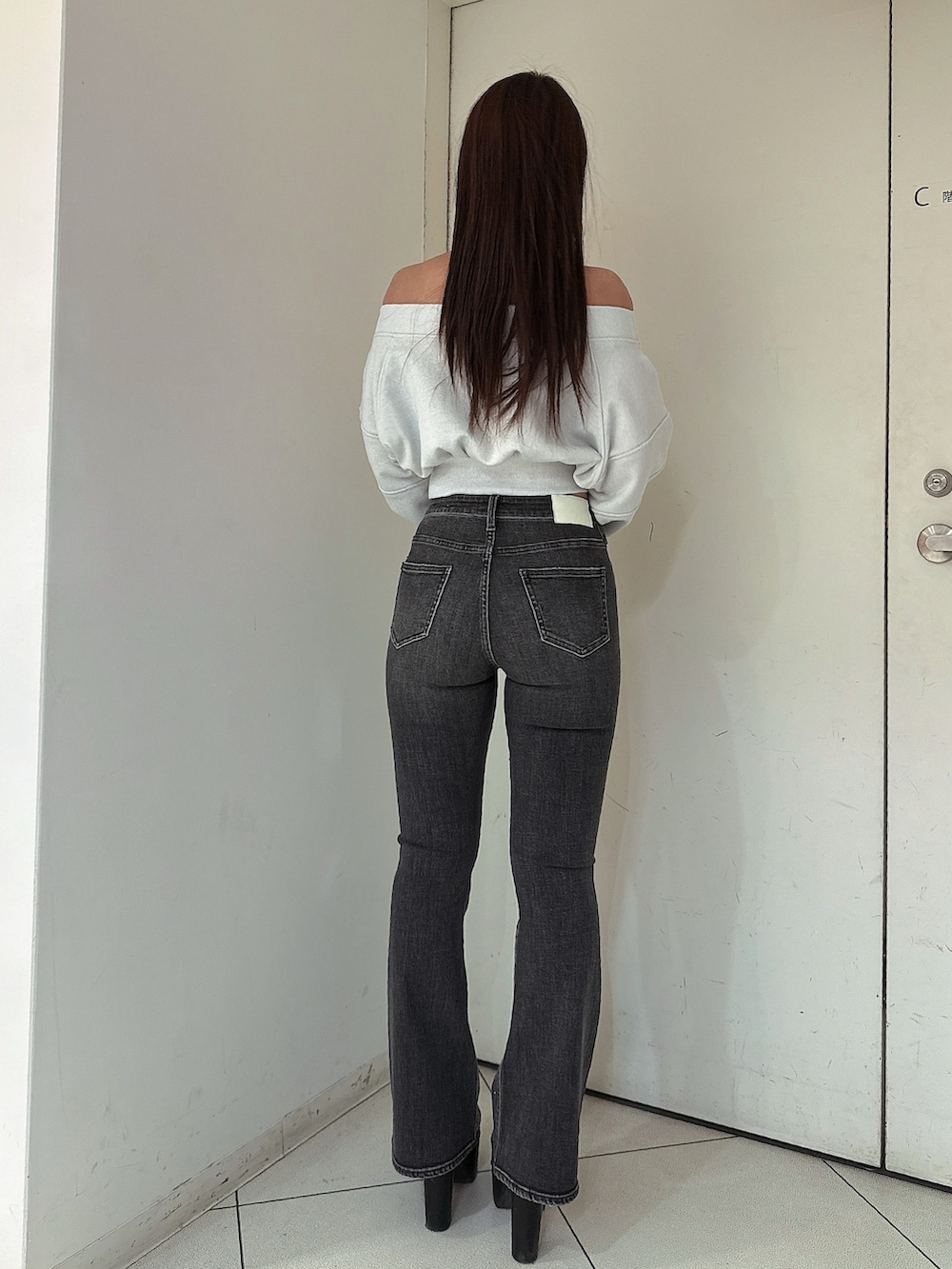 ブラック系のデニムパンツ、ブラック系のブーツ、ホワイト系のTシャツ/カットソーを着用したレディースの冬コーディネートの3枚目の写真