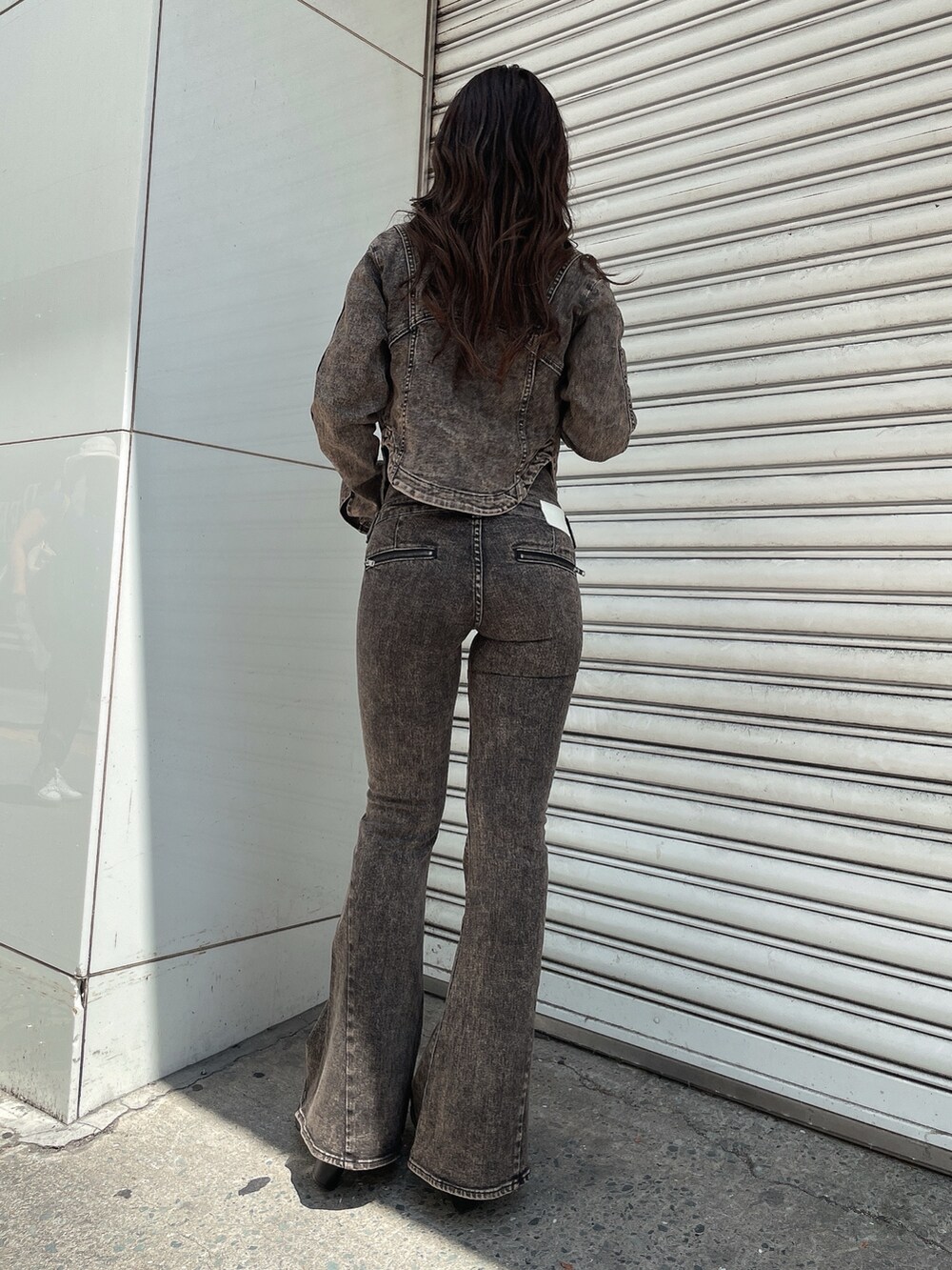 ブラック系のデニムジャケット、ブラック系のキャミソール、ブラック系のデニムパンツを着用したレディースの夏コーディネートの3枚目の写真