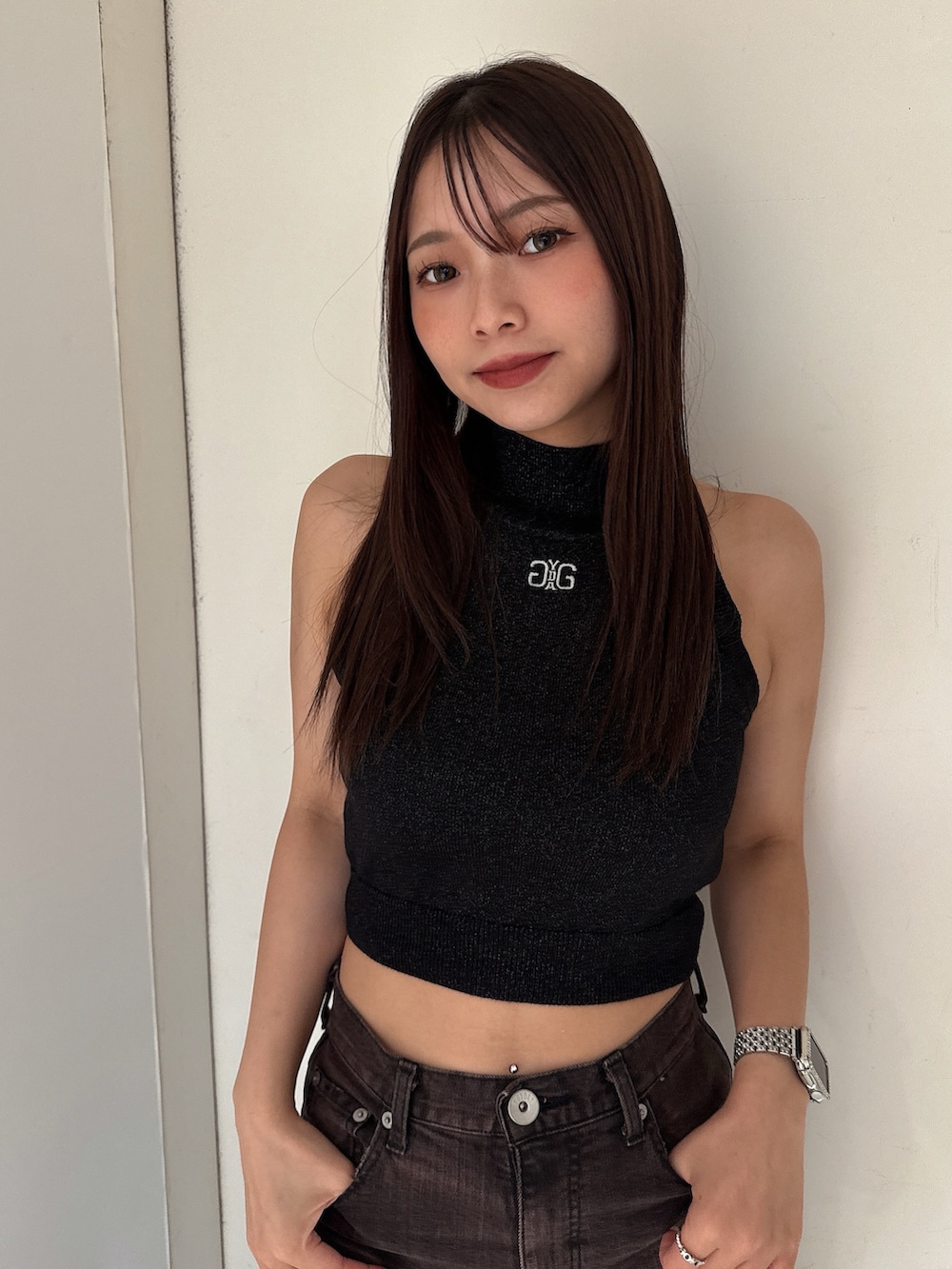 ピンク系のニット/セーター、ブラック系のサンダル、ブラック系のデニムパンツを着用したレディースの夏コーディネートの4枚目の写真