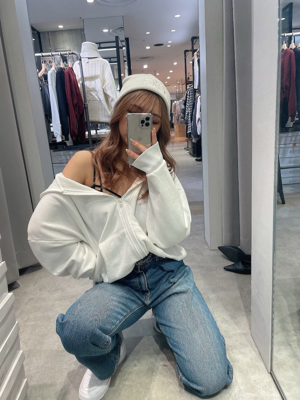 ブラック系のキャミソール、ホワイト系のパーカー、グリーン系のダウンジャケット/コートを着用したレディースの秋コーディネートの3枚目の写真