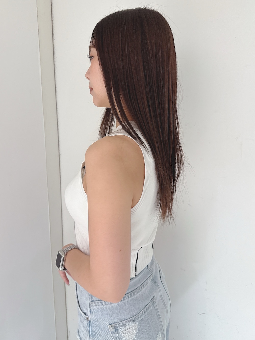 ホワイト系のニット/セーター、ブルー系のデニムパンツ、ホワイト系のサンダルを着用したレディースの夏コーディネートの5枚目の写真