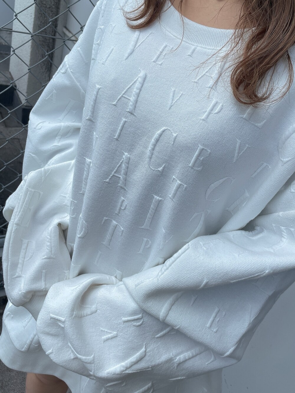 ホワイト系のスウェット、ブラック系のスカート、ベージュ系のブーツを着用したレディースの冬コーディネートの7枚目の写真