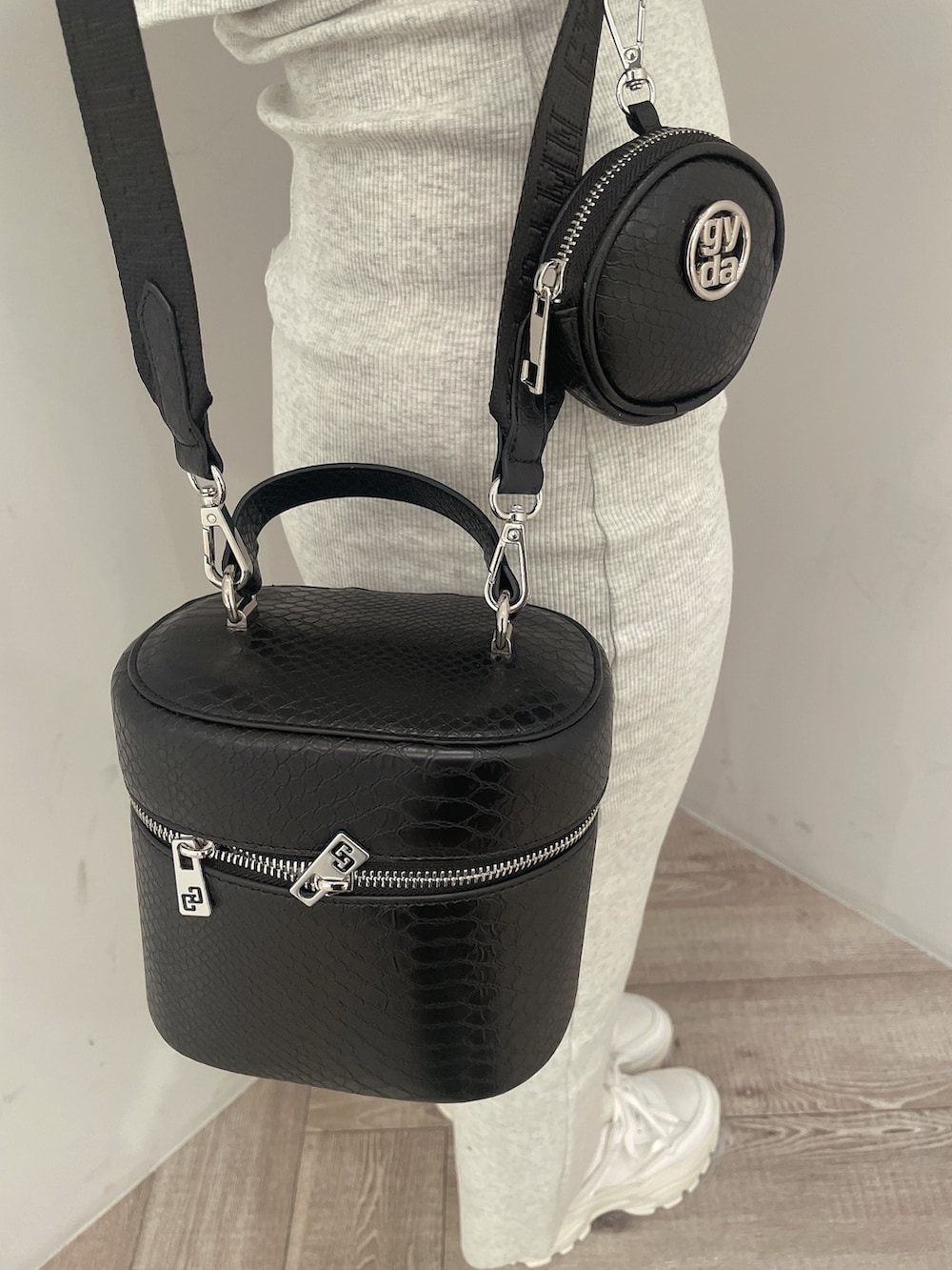 グレー系のワンピース、ブラック系のハンドバッグ、ホワイト系のスニーカーを着用したレディースの春コーディネートの9枚目の写真