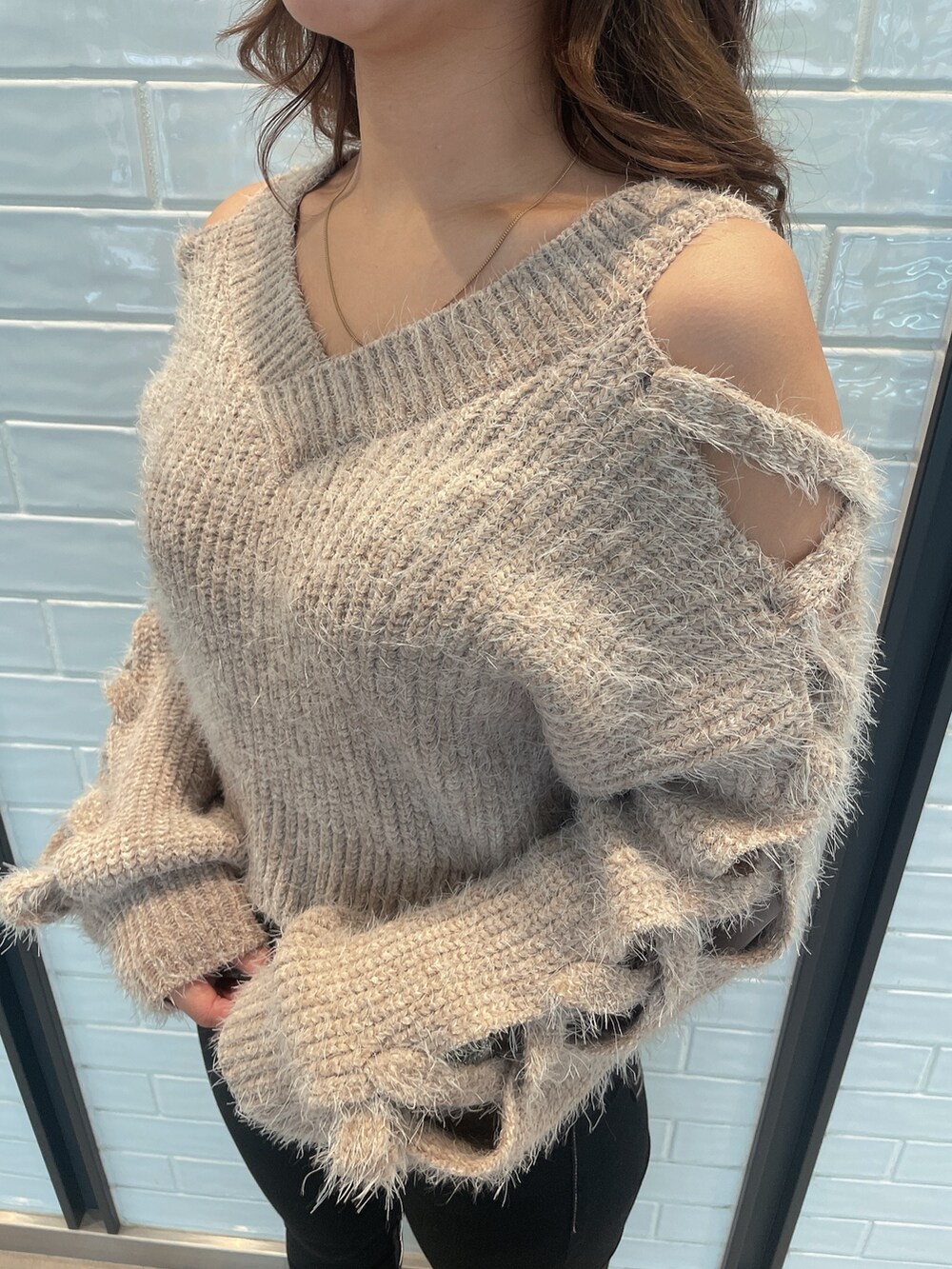 ベージュ系のニット/セーター、ブラック系のデニムパンツ、ブラック系のブーツを着用したレディースの秋コーディネートの7枚目の写真