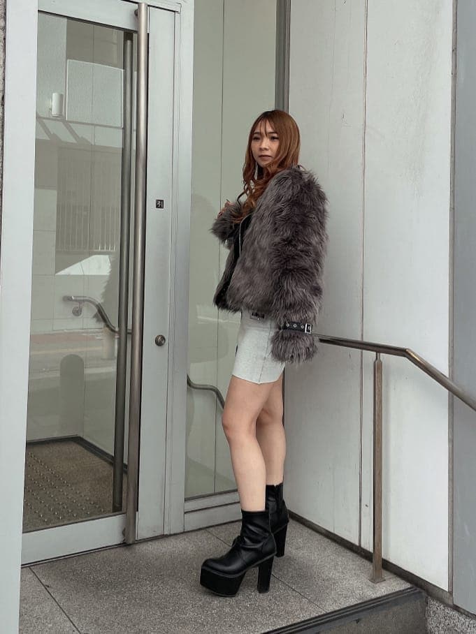 ブラック系のブーツ、グレー系のライダースジャケット、ホワイト系のワンピースを着用したレディースの秋コーディネートの3枚目の写真