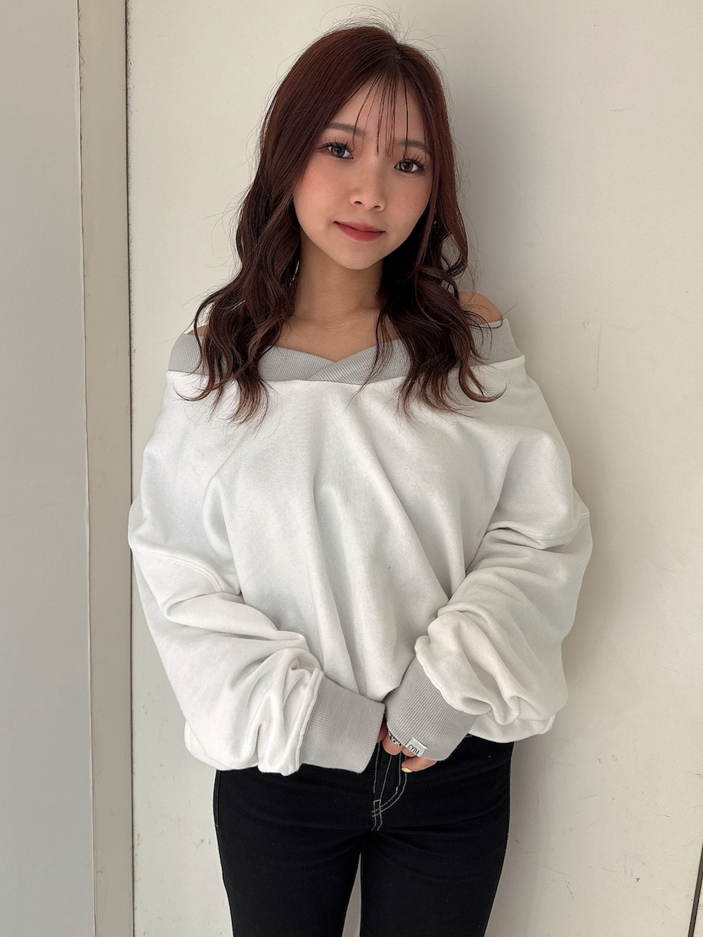 ブラック系のデニムパンツ、ホワイト系のスウェット、ホワイト系のパンプスを着用したレディースの冬コーディネートの4枚目の写真