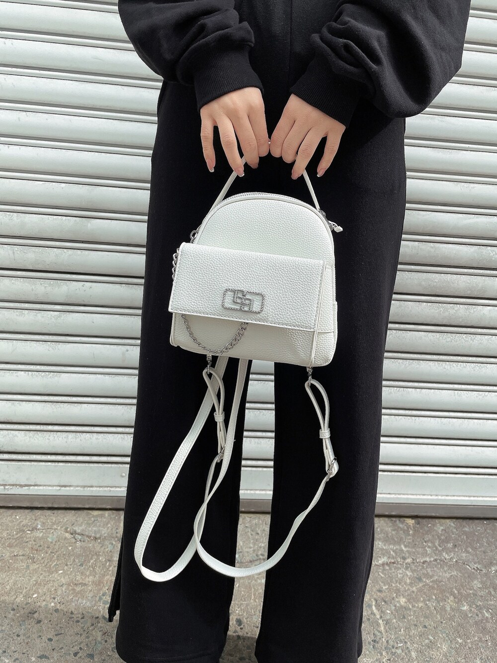 ブラック系のパーカー、ブラック系のスウェットパンツ、ホワイト系のバックパック/リュックを着用したレディースの冬コーディネートの7枚目の写真