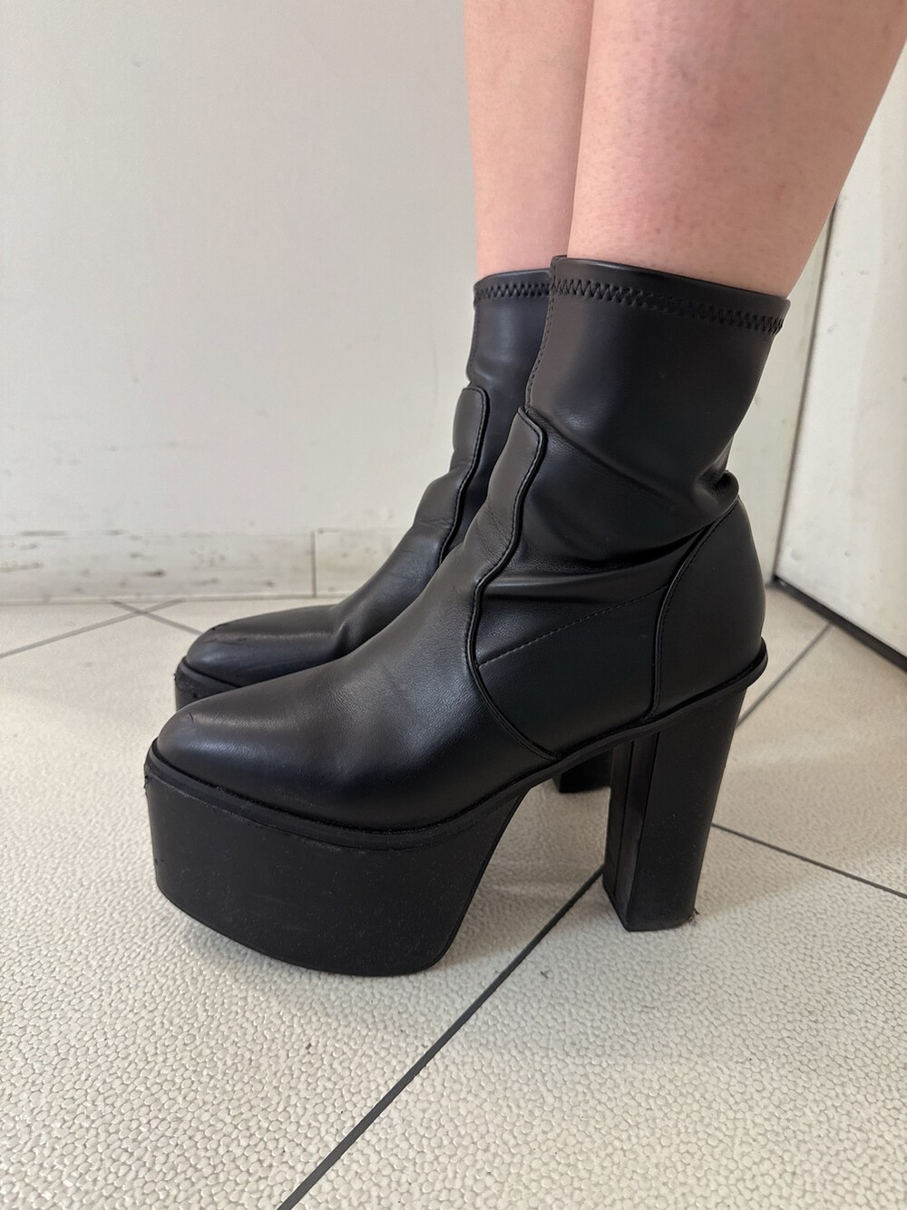 ブラウン系のニット/セーター、その他のデニムスカート、ブラック系のブーツを着用したレディースの秋コーディネートの9枚目の写真