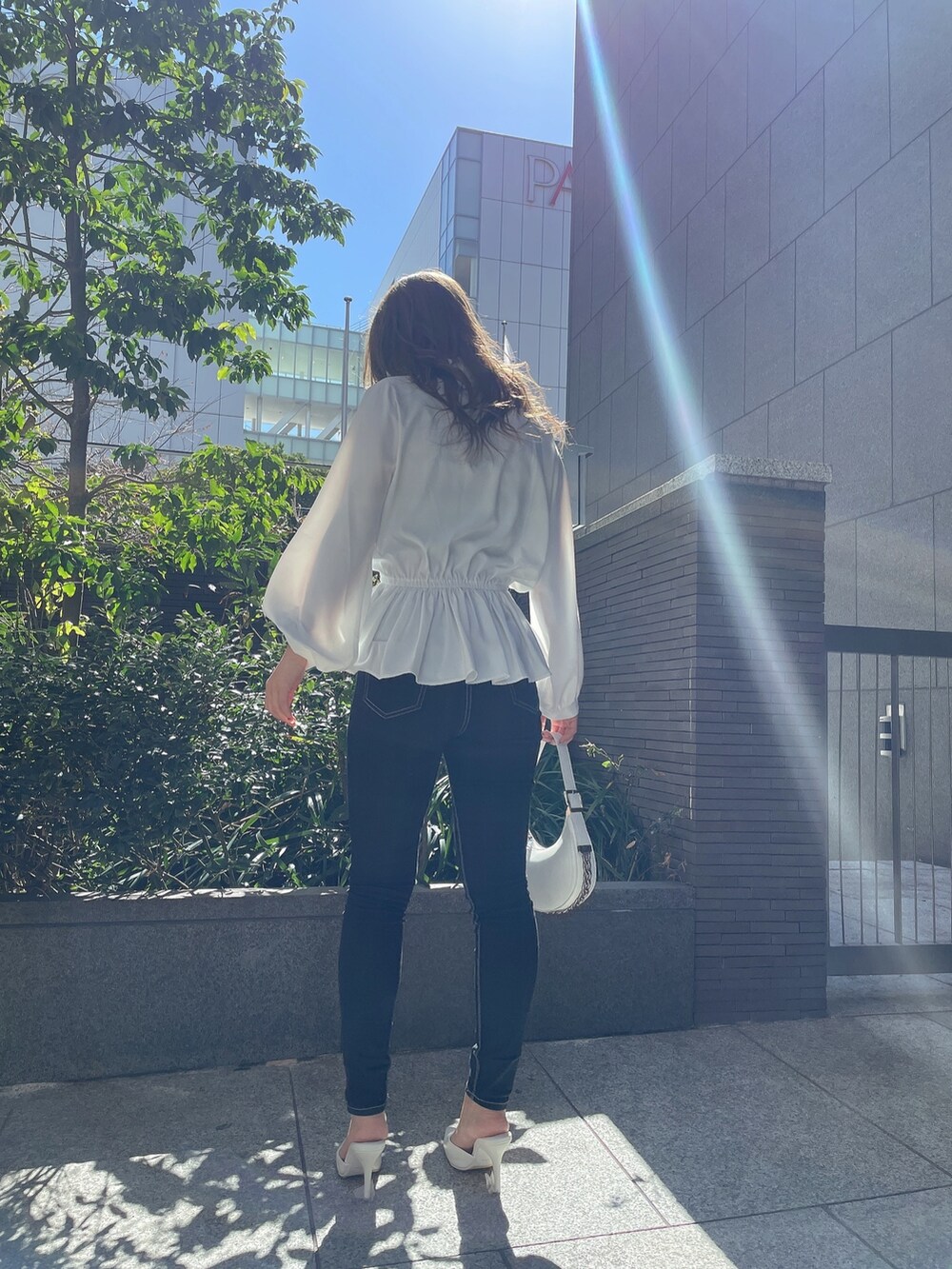 ブラック系のキャミソール、ホワイト系のシャツ/ブラウス、ホワイト系のハンドバッグを着用したレディースの冬コーディネートの2枚目の写真