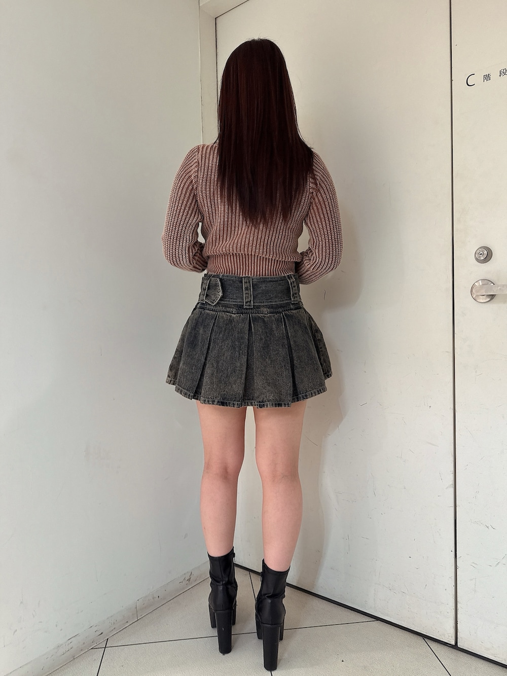 ブラウン系のニット/セーター、その他のデニムスカート、ブラック系のブーツを着用したレディースの秋コーディネートの3枚目の写真