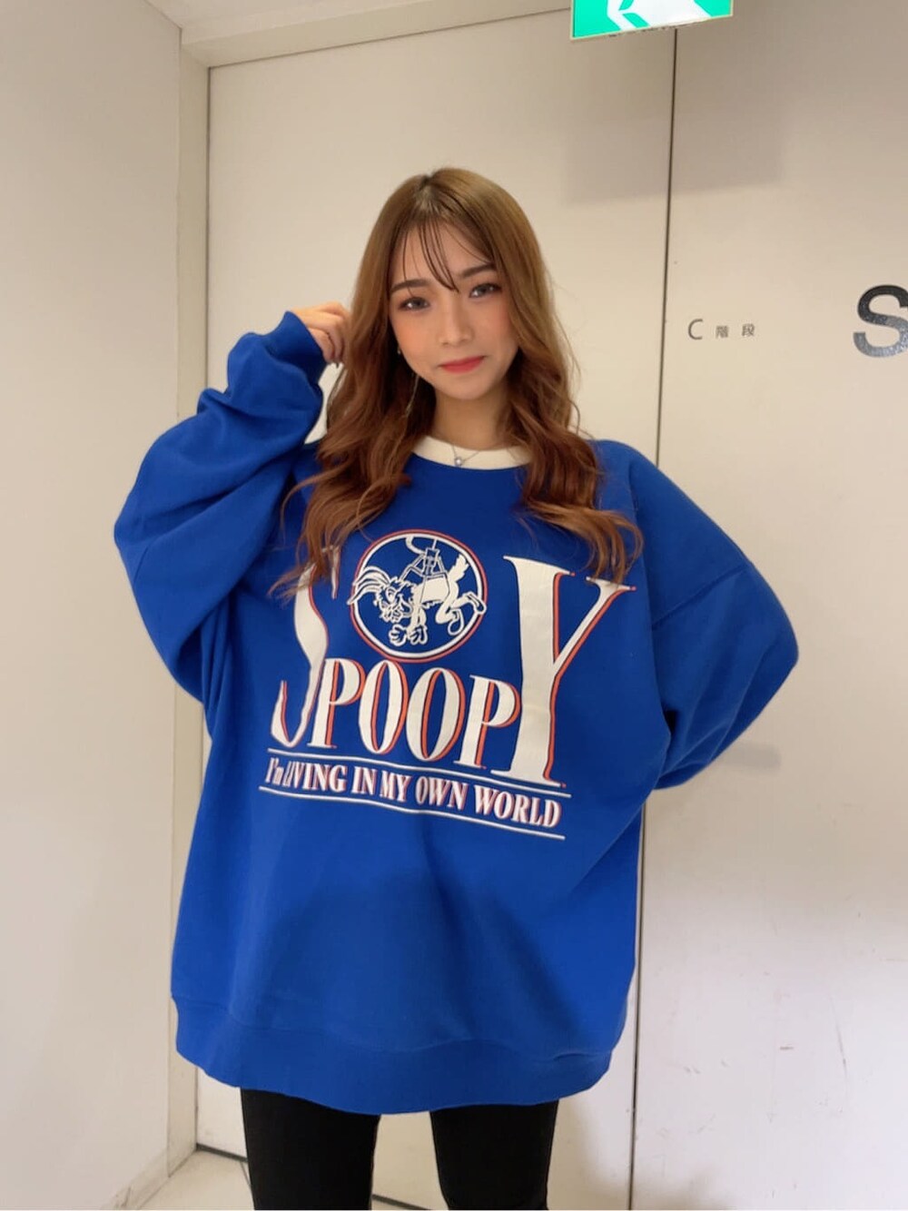 ブラック系のパンプス、ブラック系のデニムパンツ、ブルー系のスウェットを着用したレディースの秋コーディネートの3枚目の写真