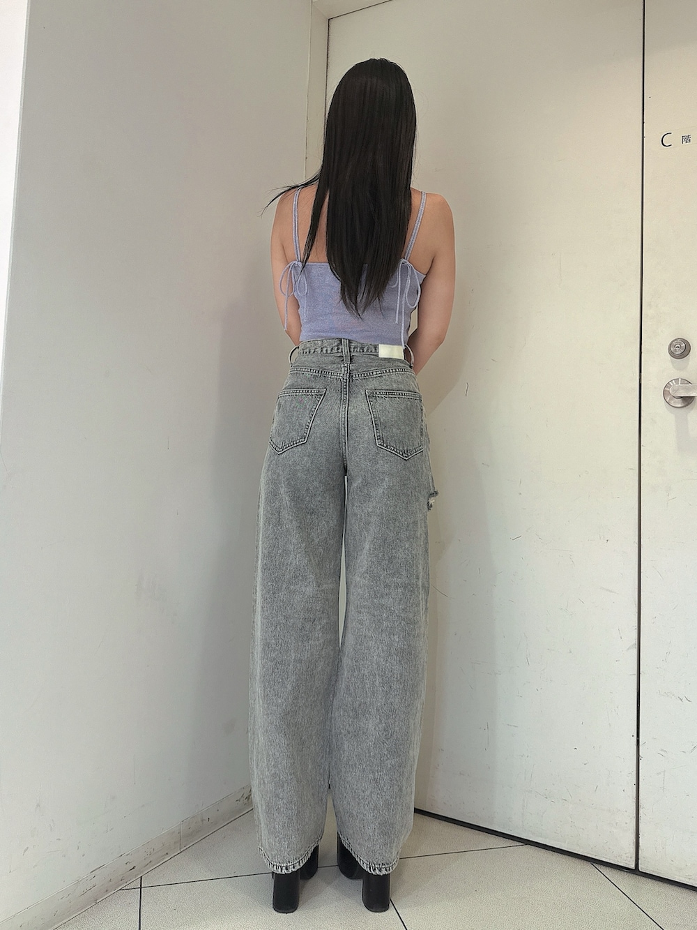 ブルー系のデニムパンツ、ブラック系のサンダル、パープル系のキャミソールを着用したレディースの春コーディネートの3枚目の写真