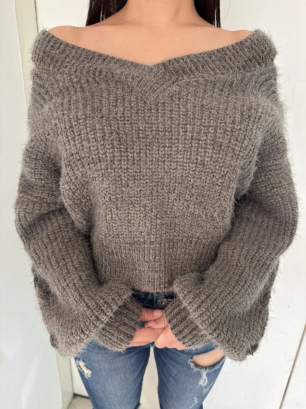 ブルー系のデニムパンツ、ブラック系のブーツ、グレー系のニット/セーターを着用したレディースの秋コーディネートの7枚目の写真