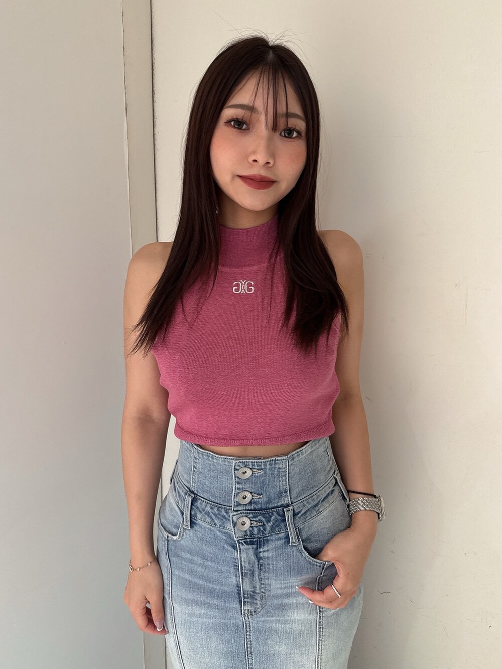 ピンク系のニット/セーター、ブルー系のデニムスカート、ホワイト系のサンダルを着用したレディースの夏コーディネートの4枚目の写真