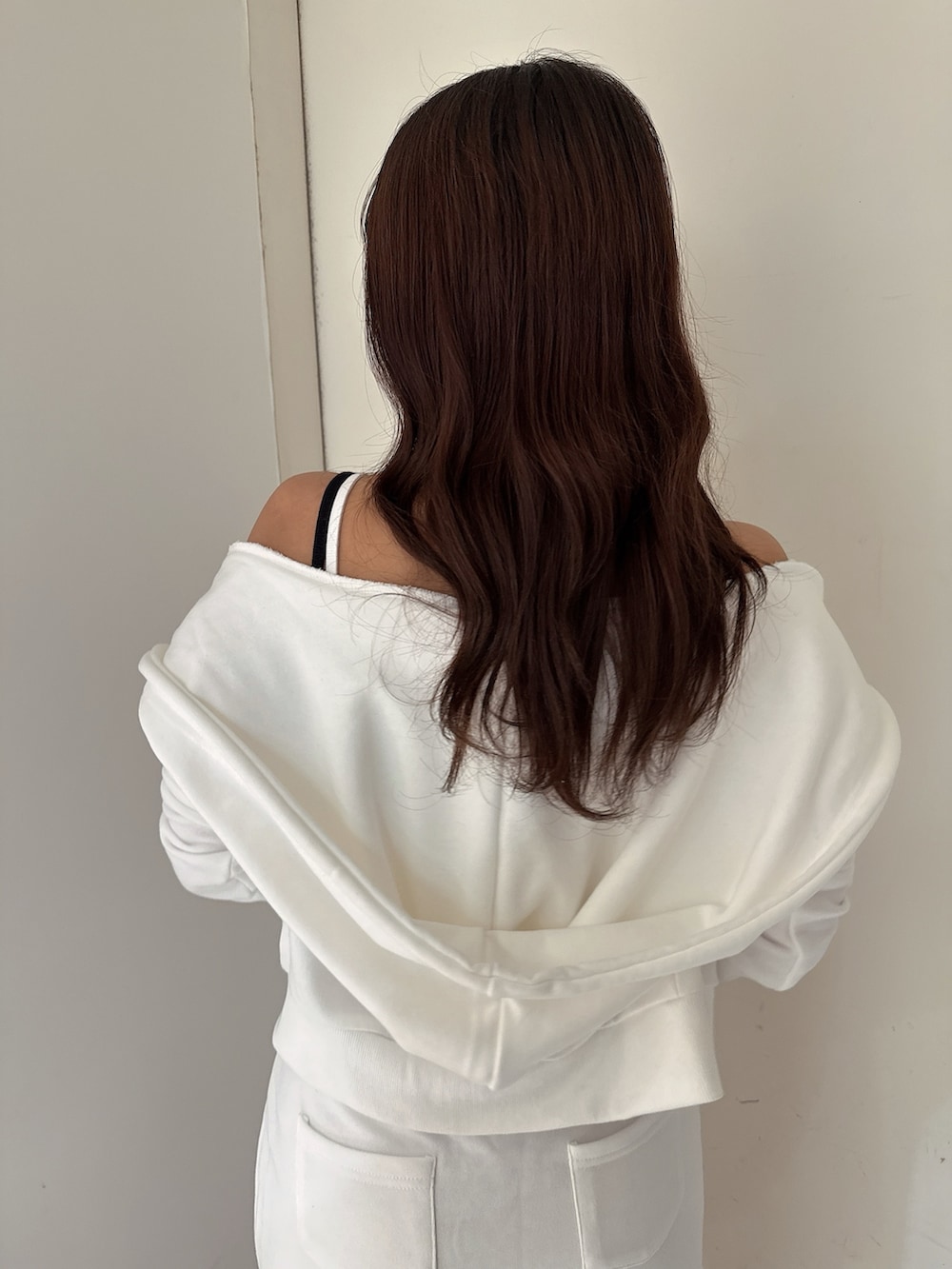 ホワイト系のキャミソール、ブラック系のサンダル、ホワイト系のパーカーを着用したレディースの夏コーディネートの6枚目の写真