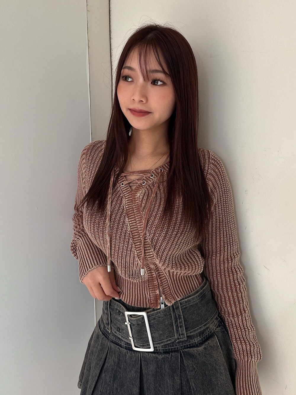 ブラウン系のニット/セーター、その他のデニムスカート、ブラック系のブーツを着用したレディースの秋コーディネートの4枚目の写真