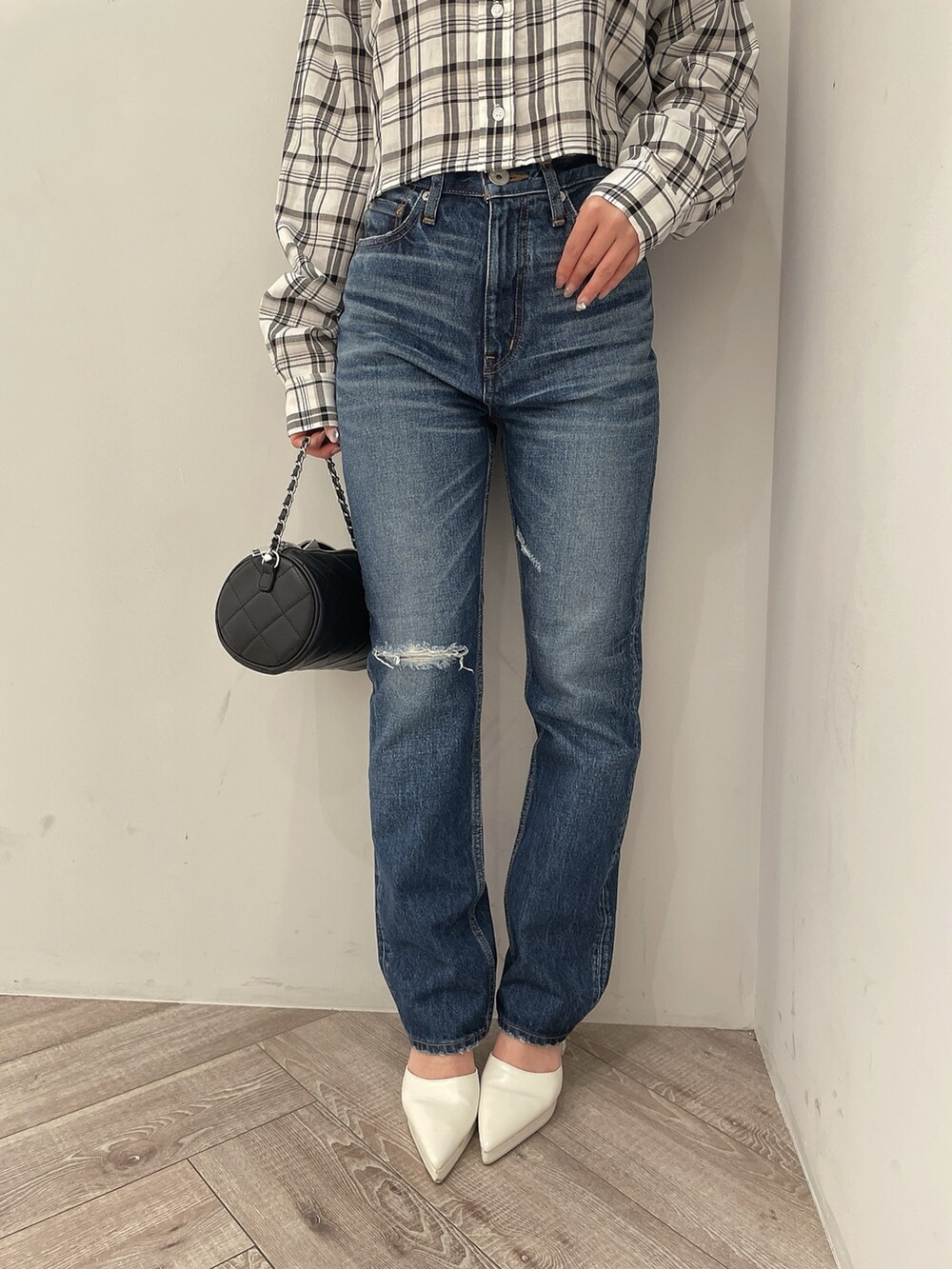 ホワイト系のシャツ/ブラウス、ブルー系のデニムパンツ、ブラック系のハンドバッグを着用したレディースの春コーディネートの6枚目の写真