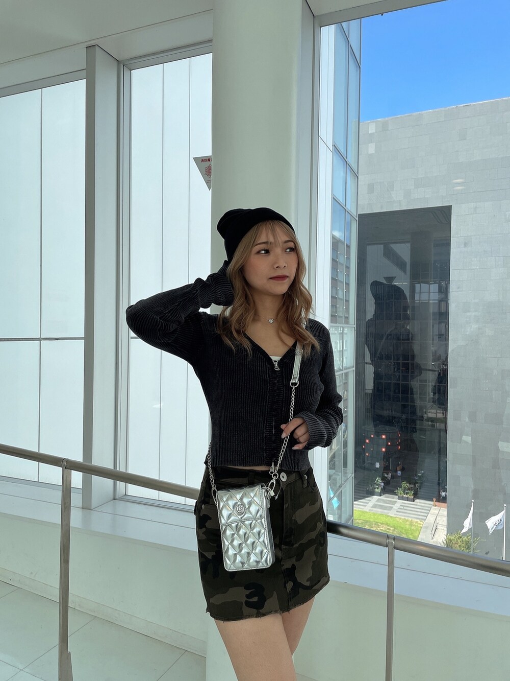 ブラック系のニット/セーター、グリーン系のスカート、ブラック系のブーツを着用したレディースの秋コーディネートの2枚目の写真