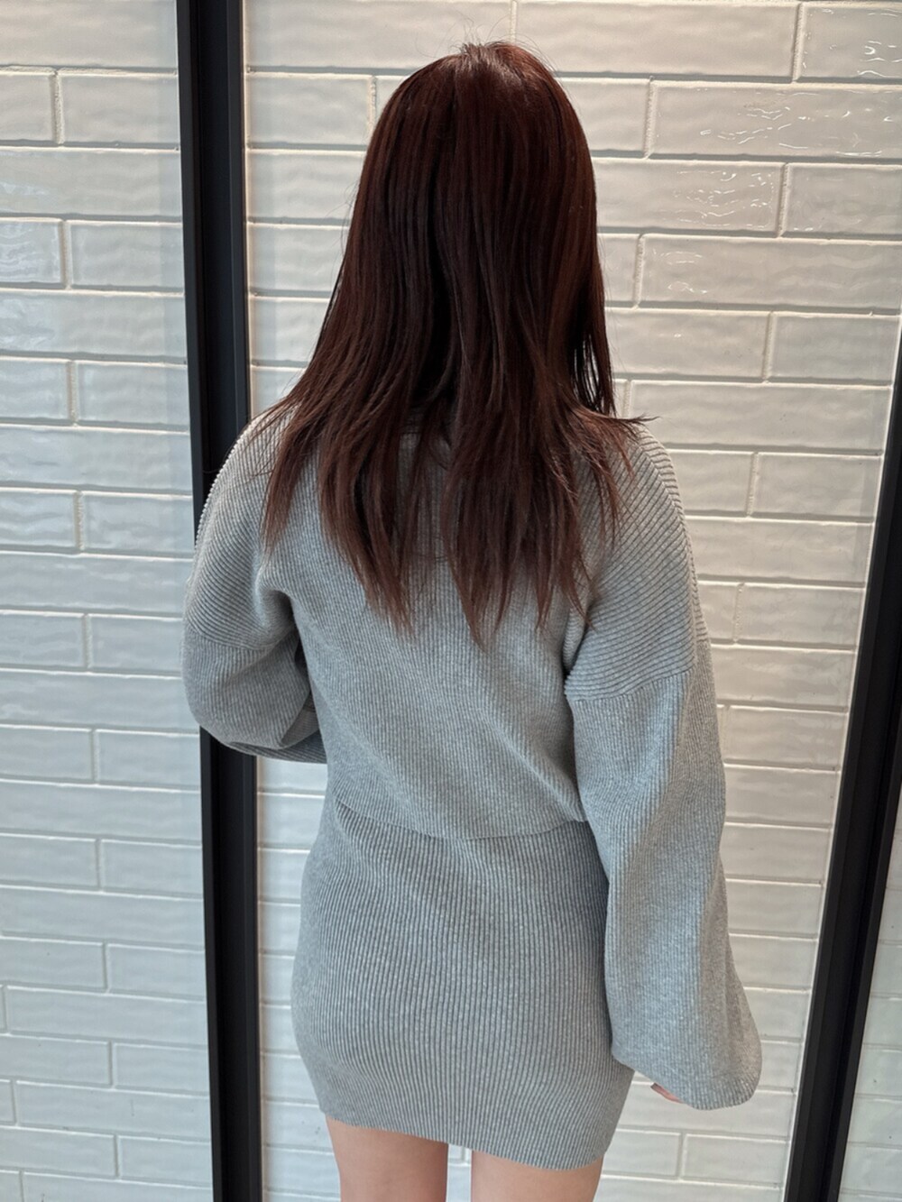 ブラック系のブーツ、グレー系のワンピースを着用したレディースの冬コーディネートの6枚目の写真