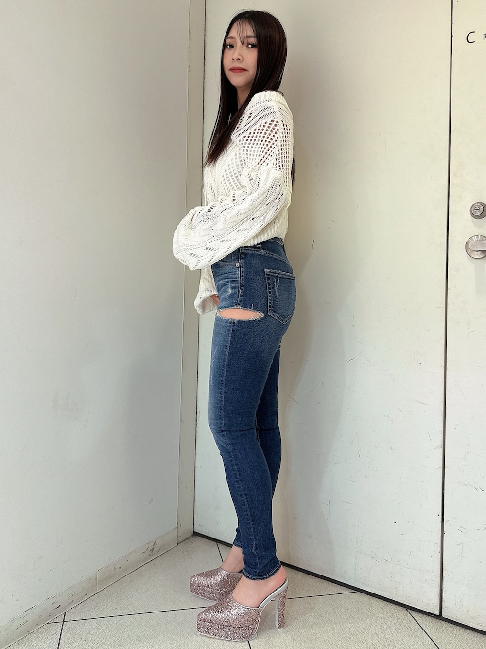 ホワイト系のニット/セーター、ブルー系のデニムパンツ、ピンク系のパンプスを着用したレディースの春コーディネートの2枚目の写真