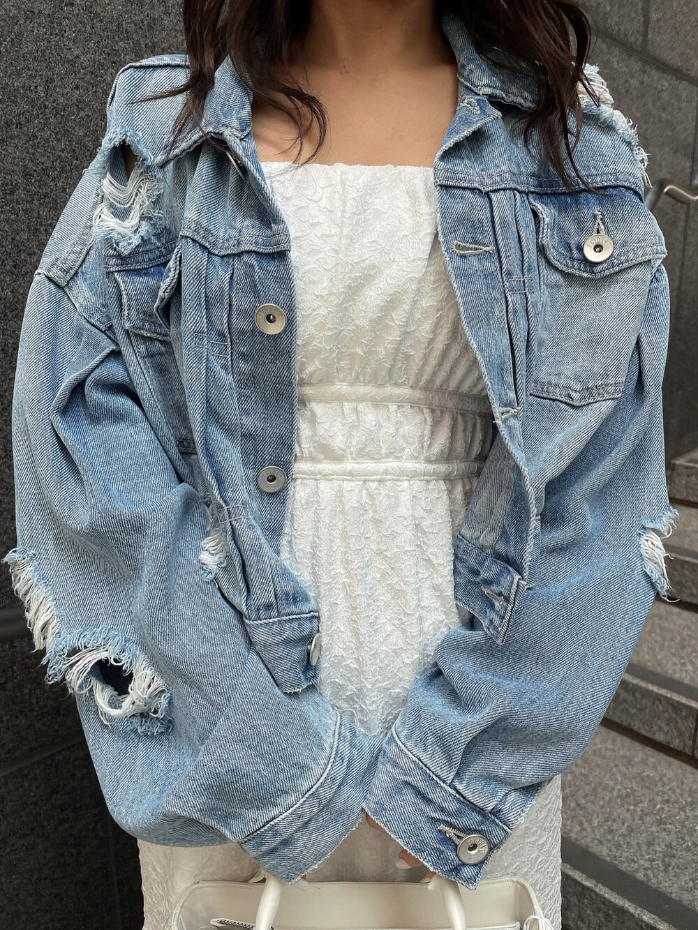 ブルー系のデニムジャケット、ホワイト系のサンダル、ホワイト系のハンドバッグを着用したレディースの春コーディネートの7枚目の写真